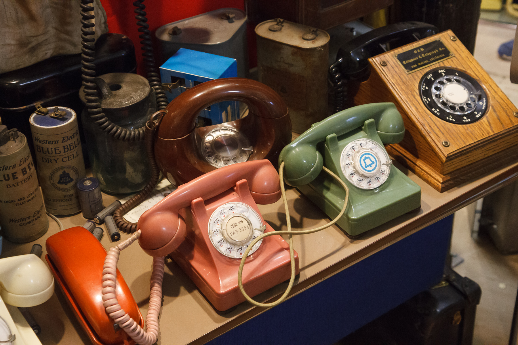 A museum table filled with old telephone equipment